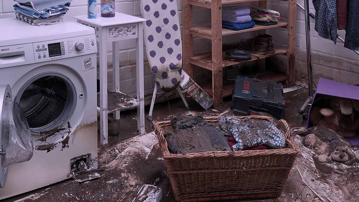 Wasruimte met een vuile wasmand en een wasmachine.